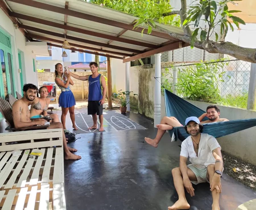 Guests chatting on the veranda, two of them lying in a hammock