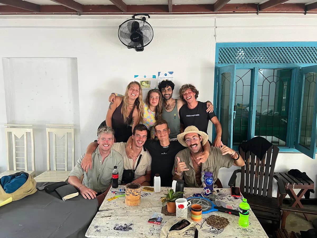 Nine guests crowded around a table in the Weligama common area, grinning at the camera
