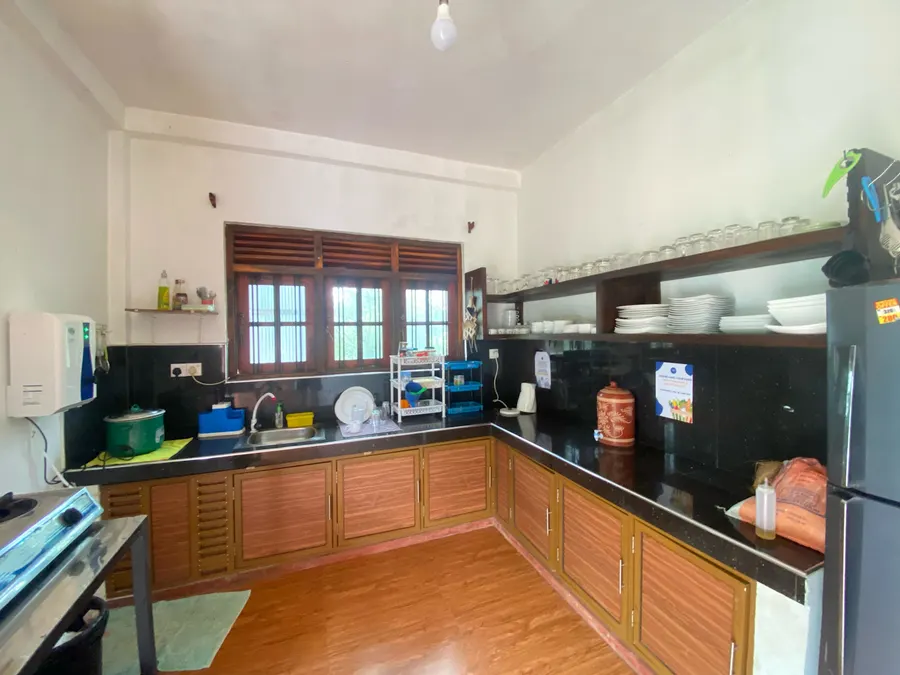 The shared kitchen, with wooden cupboards, a filtered water dispenser and a big fridge