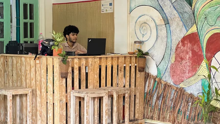 The wooden pallet reception desk beside the painted mural